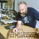 Neil Burton shows a drawer of metal letters.